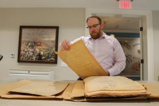 photo of Alex Bowen at the Georgia Historical Society viewing historic papers