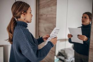 photo of a woman practicing her speech in the mirror