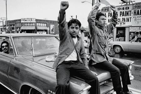 photo of men on car in parade supporting Chicano movement in U.S.