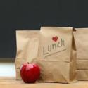 brown lunch bags and one apple